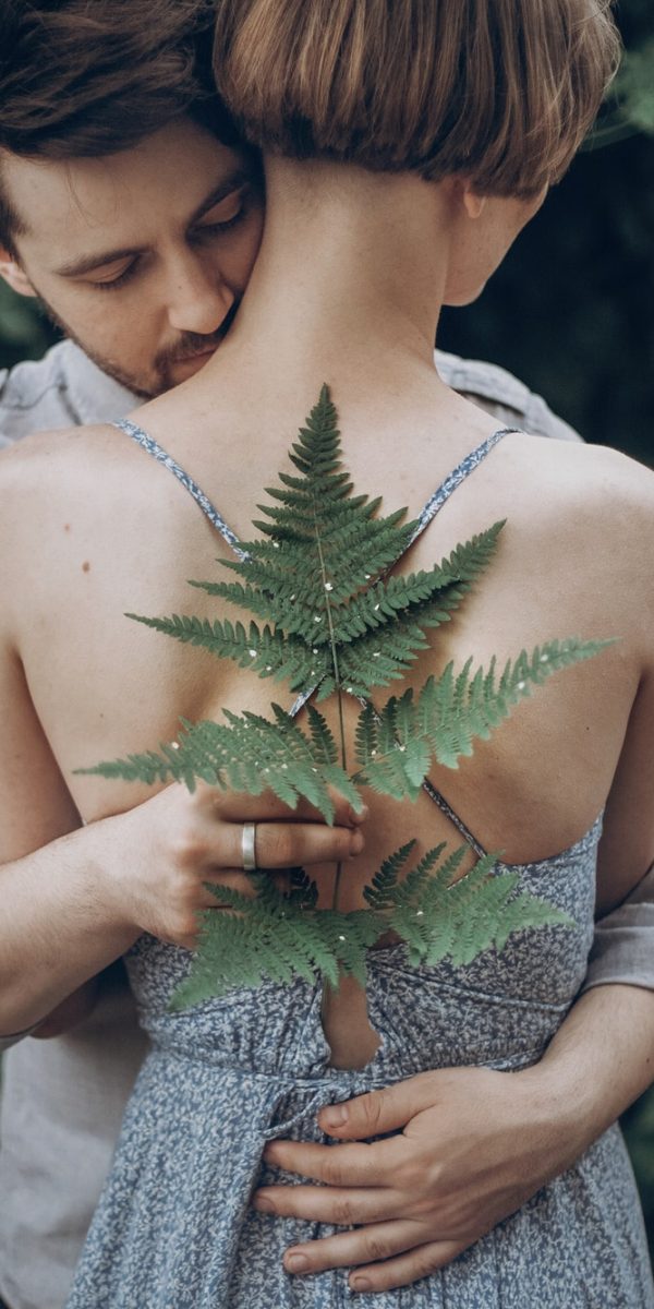 stylish-hipster-bride-and-groom-embracing-in-green-leaves-forest-man-kissing-woman-neck.jpg